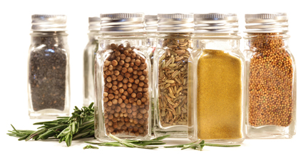 Spice jars with fresh rosmary leaves against white background